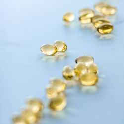 Close-up of pills spilling from bottle against blue background