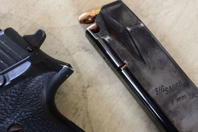 Close-up of gun with magazine on table