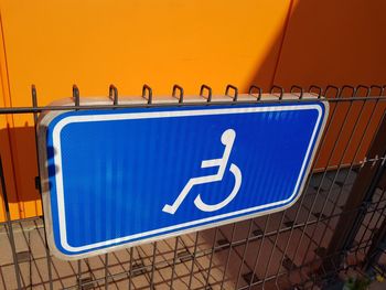 Low angle view of sign against blue wall