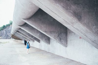 Woman standing by wall