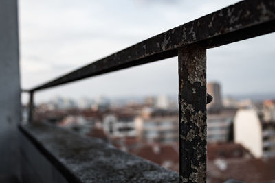 Close-up of rusty metal railing against sky
