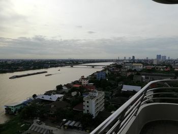 High angle view of buildings by river against sky