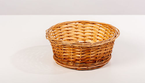 Close-up of basket on table against white background