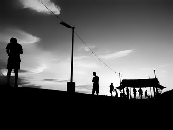 Silhouette people standing against sky