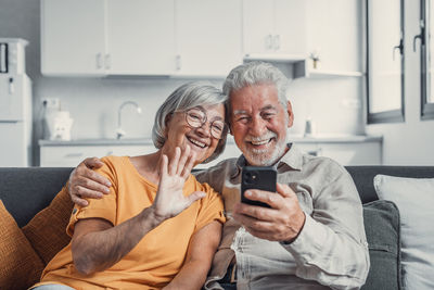 Portrait of senior woman using mobile phone while sitting at home