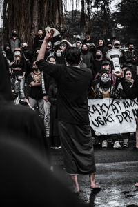 Rear view of people photographing on street