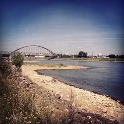 Bridge over river against blue sky