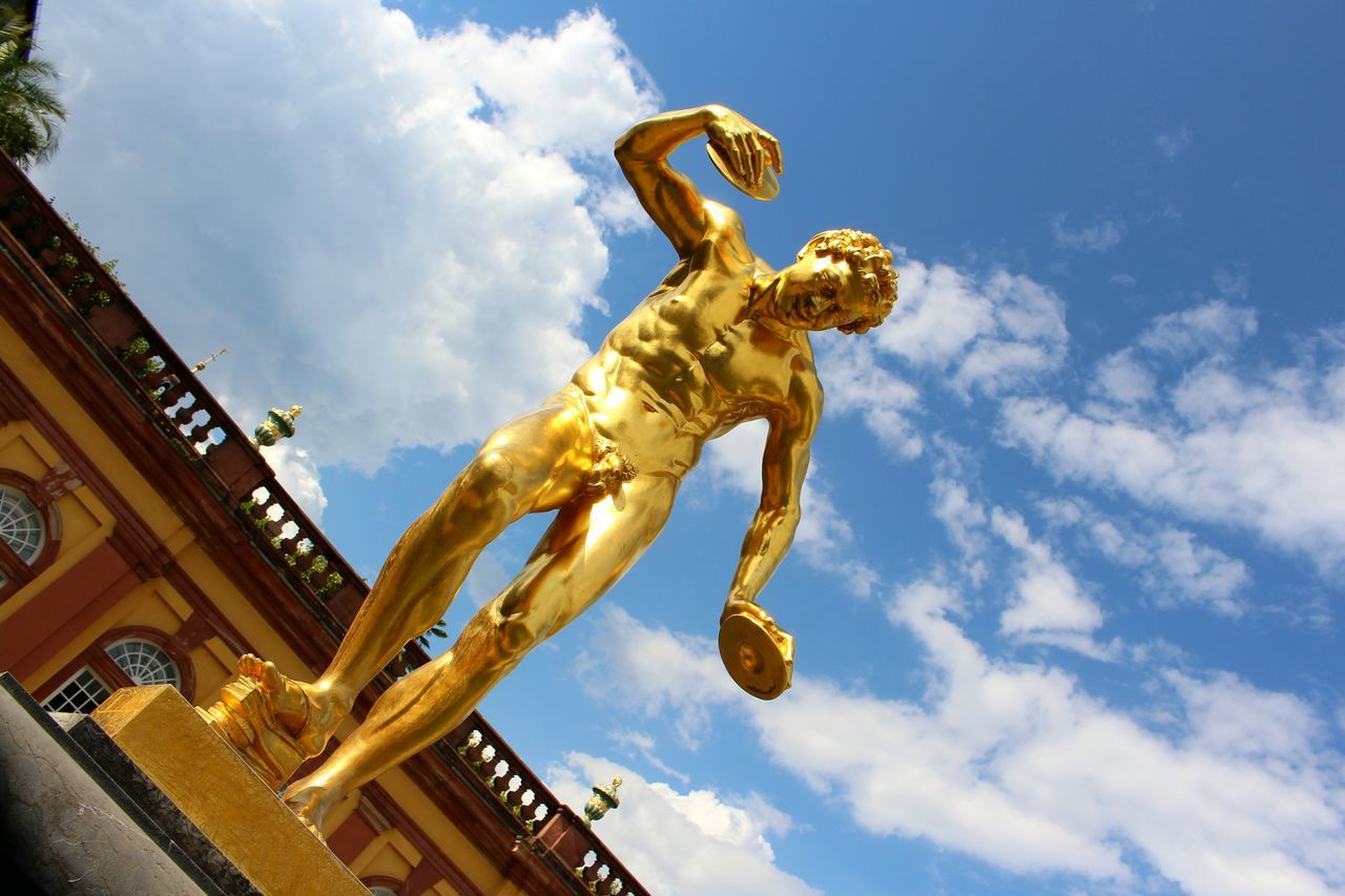 low angle view, sky, sculpture, cloud - sky, art and craft, human representation, yellow, cloud, outdoors, monument, creativity, day, cloudy, history, famous place