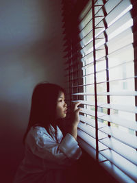 Girl looking through window