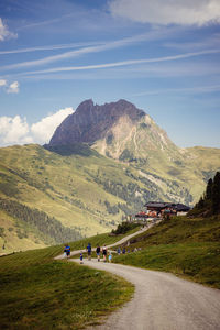 Scenic view of road by mountains against sky