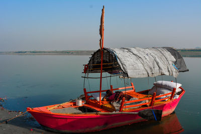 Boat moored on beach against clear sky