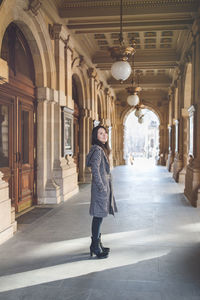 Beautiful middle-aged japanese woman in stylish coat, smiling. urban street portrait. sunlight