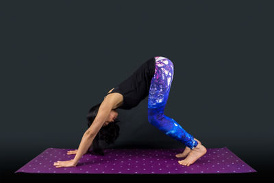 Midsection of person wearing mask against black background