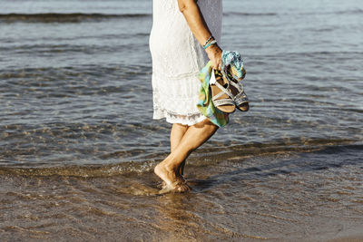 Close-up of senior woman wading in the sea, el roc de sant gaieta, spain