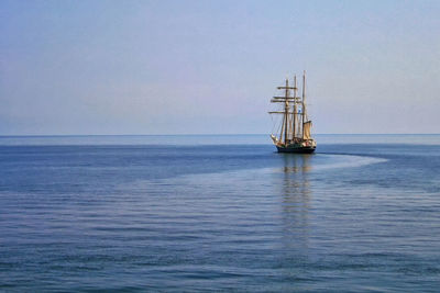 Sailboat sailing on sea against sky