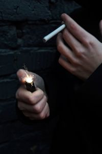 Close-up of person igniting cigarette with lighter