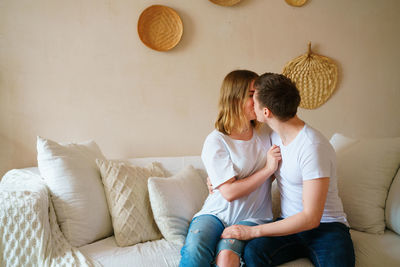 Side view of woman sitting on sofa at home