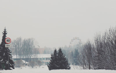 Snow covered land against clear sky