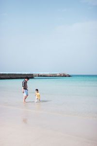 People enjoying on beach against sky