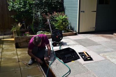 High angle view of worker repairing drain