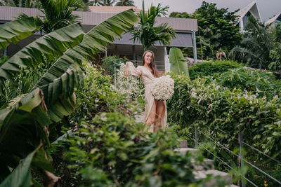 Rear view of woman standing by plants