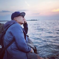 Side view of young man against sea during sunset