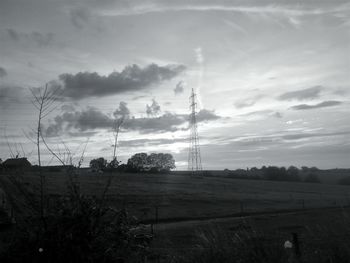 Low angle view of electricity pylon on field against sky