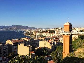 High angle view of buildings and sea against clear blue sky