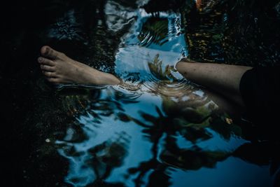 Cropped image of persons legs in pond