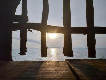 Pier over sea against sky during sunset