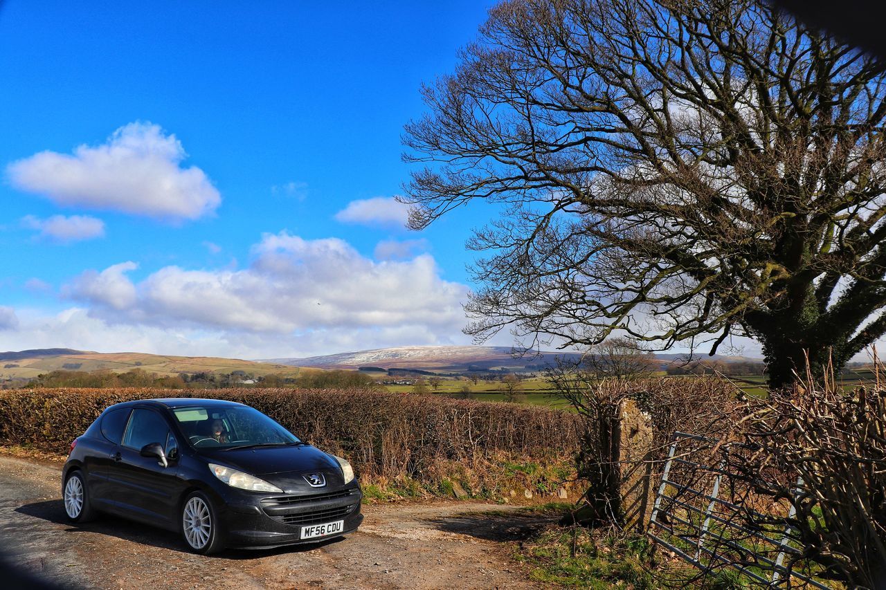 VINTAGE CAR ON LANDSCAPE AGAINST BLUE SKY