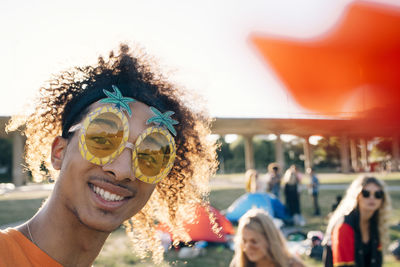 Close-up portrait of smiling man wearing novelty glasses at music concert