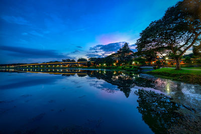 Scenic view of lake by building against blue sky