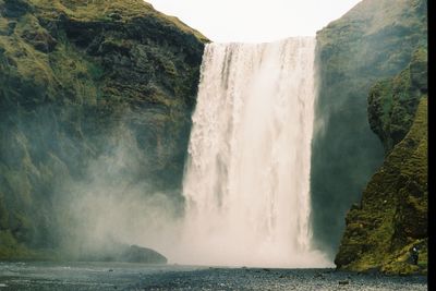 Scenic view of waterfall against sky