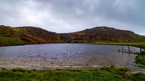 Scenic view of lake by mountains against sky