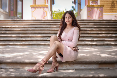 Portrait of young woman sitting on staircase