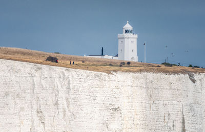 Low angle view of lighthouse on cliff against sky