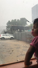 Boy looking through car window