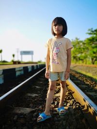 Full length of a girl standing on railroad track