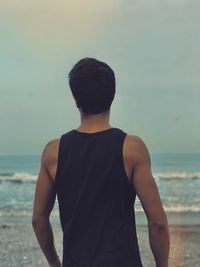 Rear view of man standing at beach