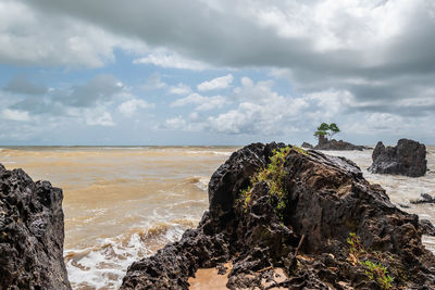 Rock formation on beach against sky