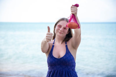 Portrait of woman standing at beach