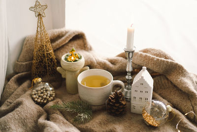 Hot tea, candles, christmas golden balls and decorations. christmas holiday mood