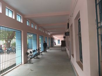 Rear view of people walking in corridor of building