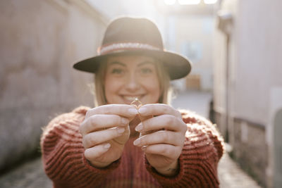 Portrait of smiling young woman holding ring 