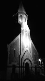 Low angle view of illuminated building against sky at night