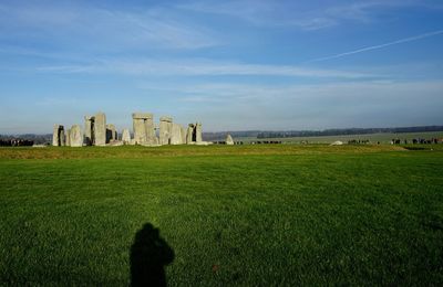 Shadow of person on field against sky