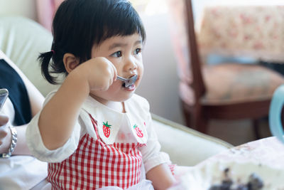 Cute girl eating food at home