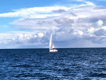 Sailboat sailing on sea against sky