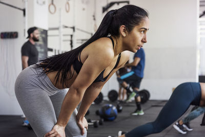 Tired athlete standing after cross fit training in crossfit gym